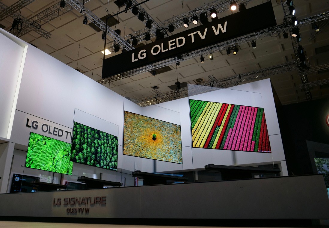 Four LG SIGNATURE OLED TV W sets placed side by side on a display stand rotate simultaneously.