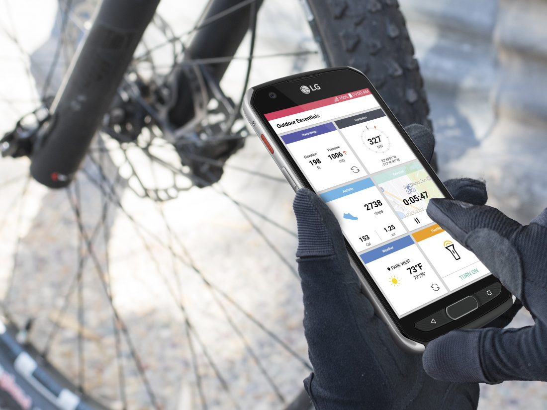 Close-up view of a person’s hands while they are using the LG X Venture to check the Outdoor Essentials
