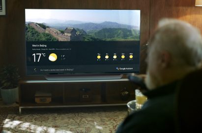 An old man asks LG's ThinQ-enabled TV for the weather forecast of Beijing for his travel.