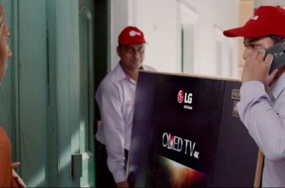 A screenshot of LG India’s “Astronaut” video, two men are delivering LG OLED TV to a woman’s house.