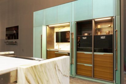 Corner of the SIGNATURE KITCHEN SUITE showing a sink, the no handle oven and induction cooktop made with black glass