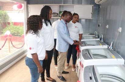 A man explains LG washing machine features to the event's attendants during public event.