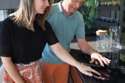 Two attendees touch the furniture at the LG Eco-City Garden booth.