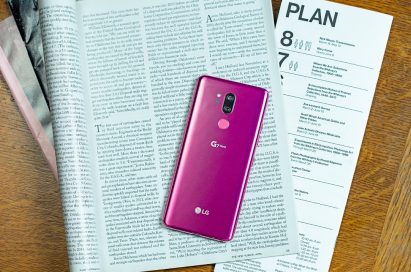 The LG G7 ThinQ in Raspberry Rose face down on top of an open magazine