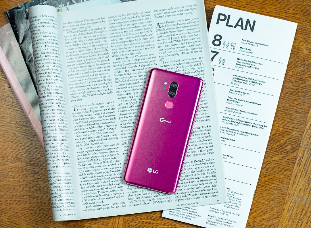 The LG G7 ThinQ in Raspberry Rose face down on top of an open magazine