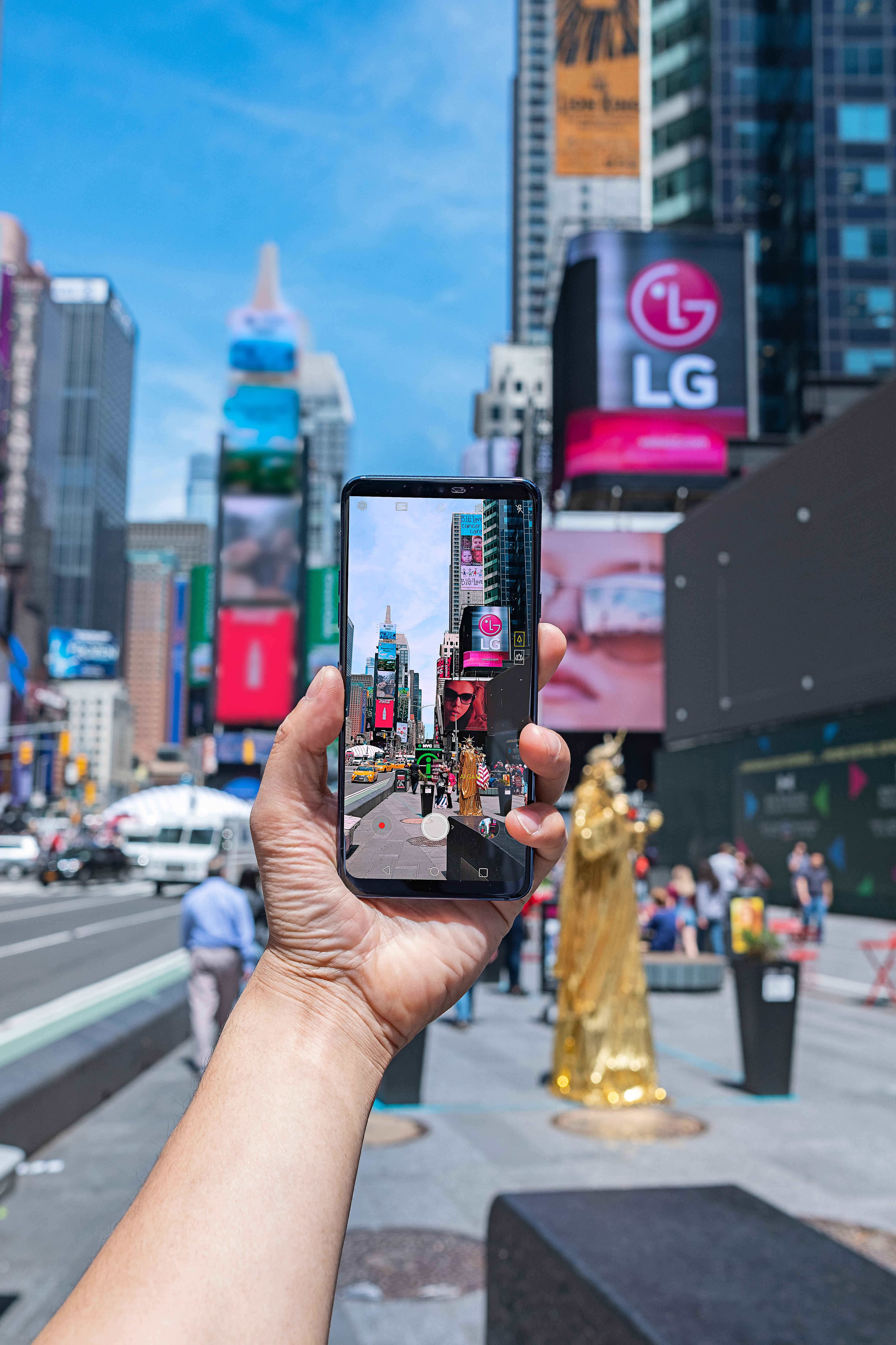 A person taking a photo of Times Square in New York with AI CAM on the LG G7 ThinQ