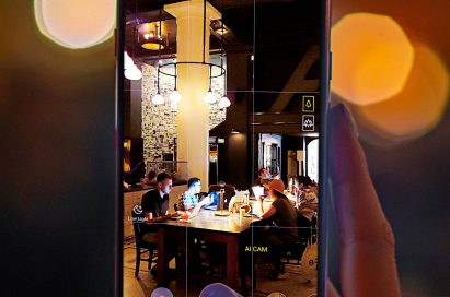 A person taking a photo of a dark cafe with AI CAM on the LG G7 ThinQ