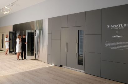 2 women and 1 man viewing wine cellars at SIGNATURE KITCHEN SUITE’s exhibition hall cooperated with Arclinea at IFA 2018