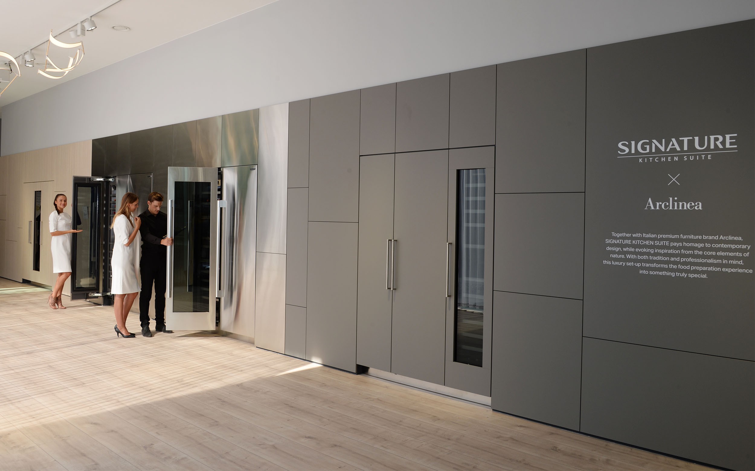 2 women and 1 man viewing wine cellars at SIGNATURE KITCHEN SUITE’s exhibition hall cooperated with Arclinea at IFA 2018