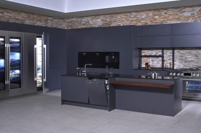 A kitchen consisting of SIGNATURE KITCHEN SUITE collection in black backdrop with brick walls