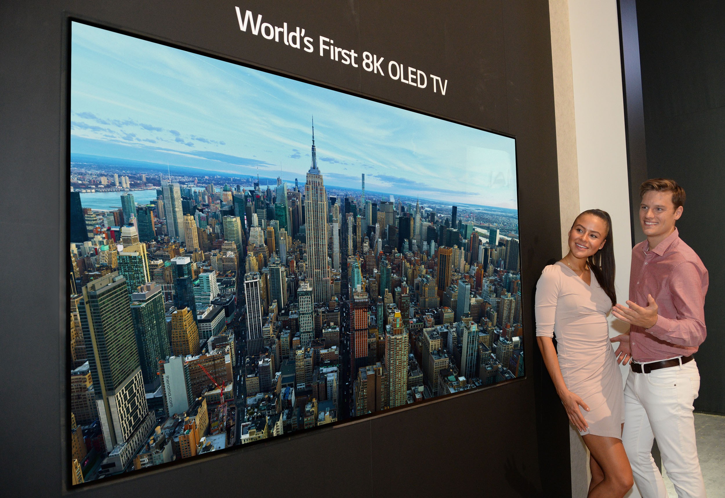 Two models look in awe at the world’s first LG 8K OLED TV displayed at IFA 2018