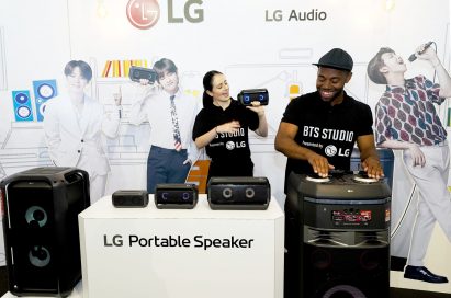 A man and woman both test LG’s speaker products at the BTS Studio Presented by LG.