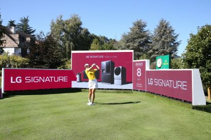 A golfer hits a ball right in front of the LG Signature signage.