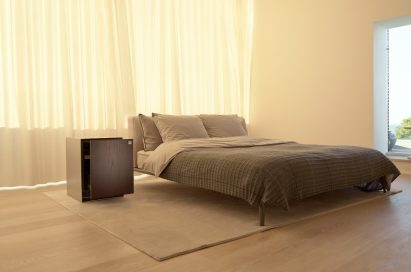 LG OBJET Refrigerator positioned next to a bed in an apartment