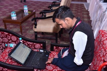 A participant looks down at his laptop computer