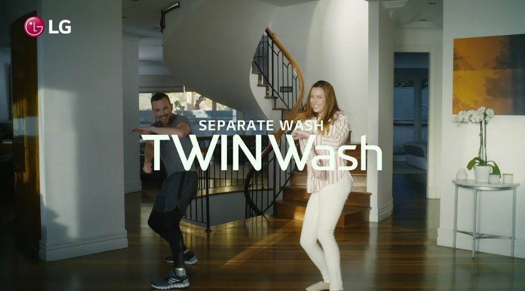 A screenshot from the LG TWINWash Dance Challenge video clip, a man and a woman dance to the music with smiles on their faces