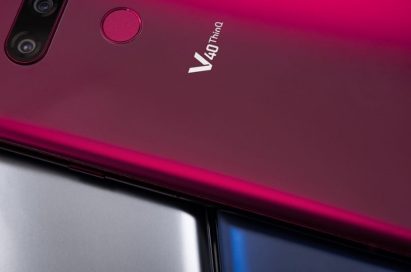 A Carmine Red LG V40 ThinQ is placed on LG V40 ThinQ smartphones in two different colors – New Platinum Grey and New Moroccan Blue.