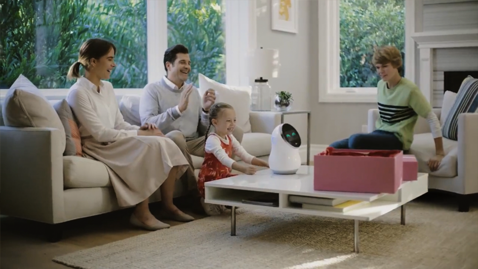 Four members of a family enjoy their time together using LG’s CLOi Hub Robot in the living room.