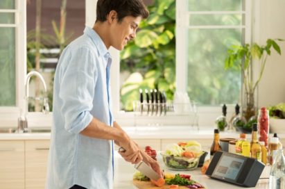 Man slicing vegetables as he looks at a recipe on the LG XBOOM AI ThinQ™ WK9 Smart Display