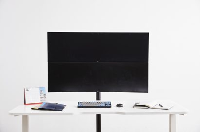 Front view of the LG UltraWide monitor model 49WL95 with office supplies sitting on a desk