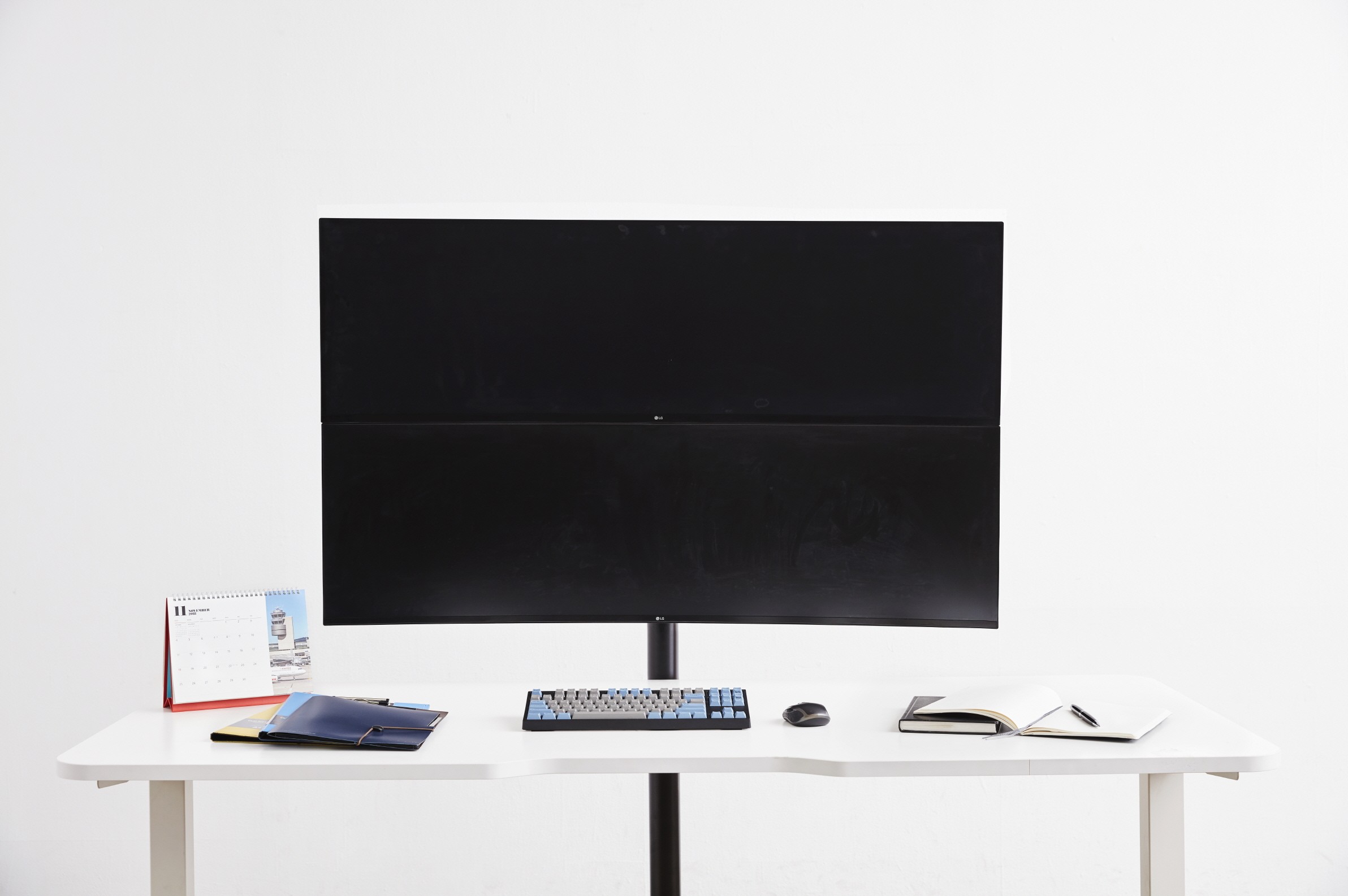 Front view of the LG UltraWide monitor model 49WL95 with office supplies sitting on a desk