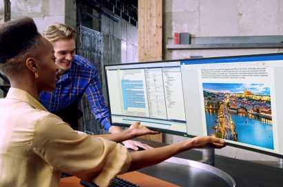 A man and a woman looking at content from multiple sources side-by-side with the LG UltraWide monitor model 49WL95