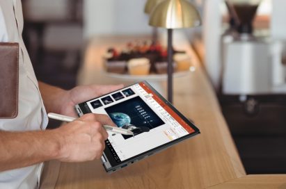 A close-up of a man touching the display of LG gram while making a presentation for work