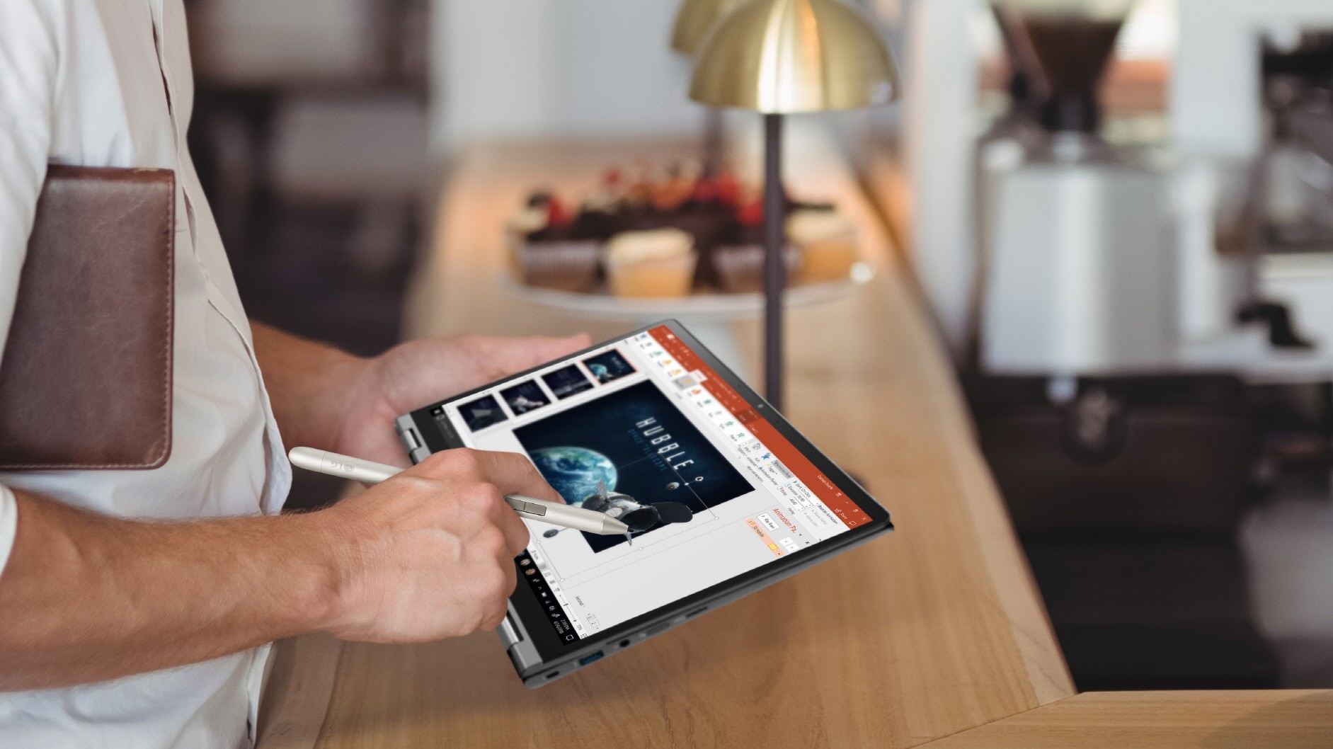 A close-up of a man touching the display of LG gram while making a presentation for work