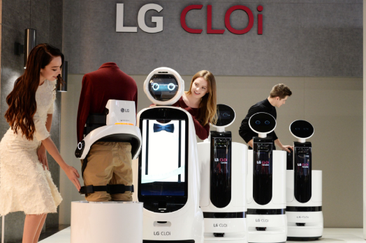Female and male models look around the LG’s CLOi commercial robot samples.