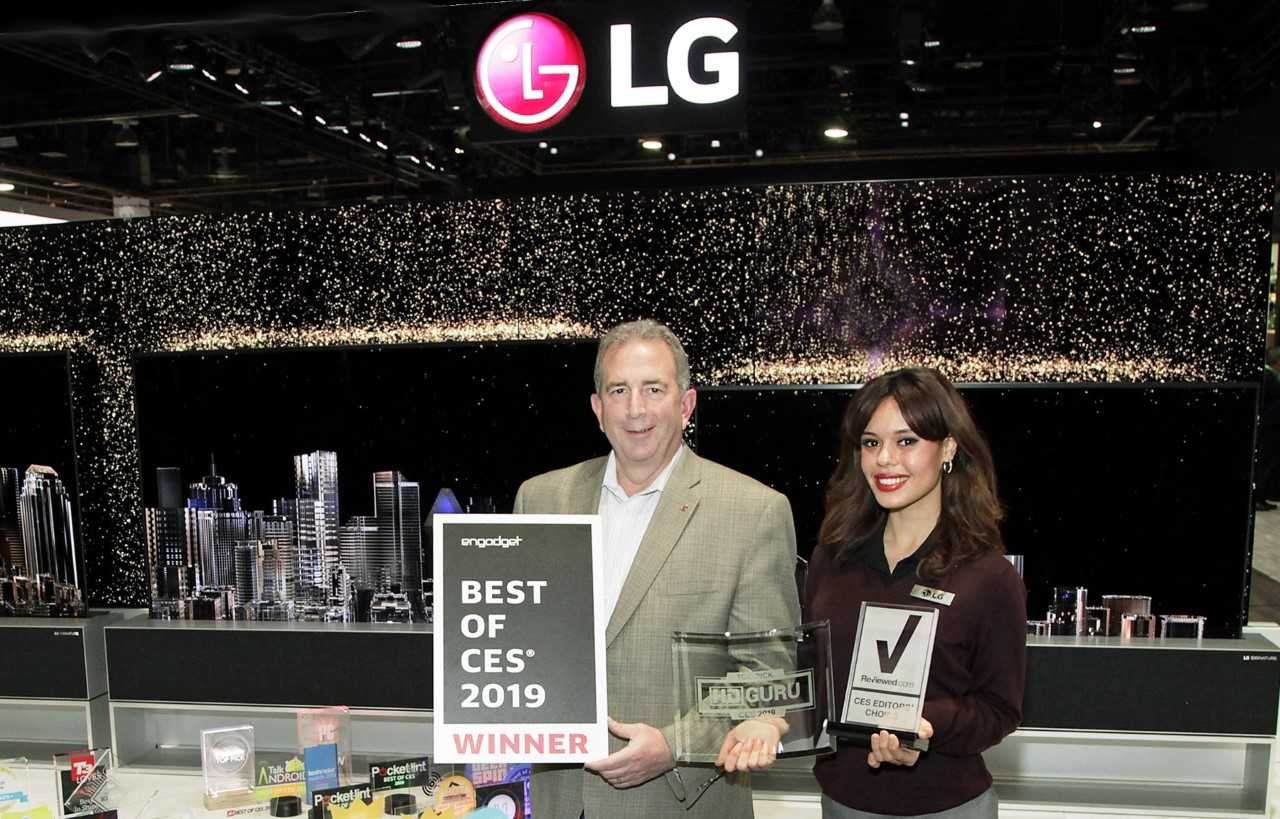 LG representatives pose with awards from Engadget, HD Guru and Reviewed.com