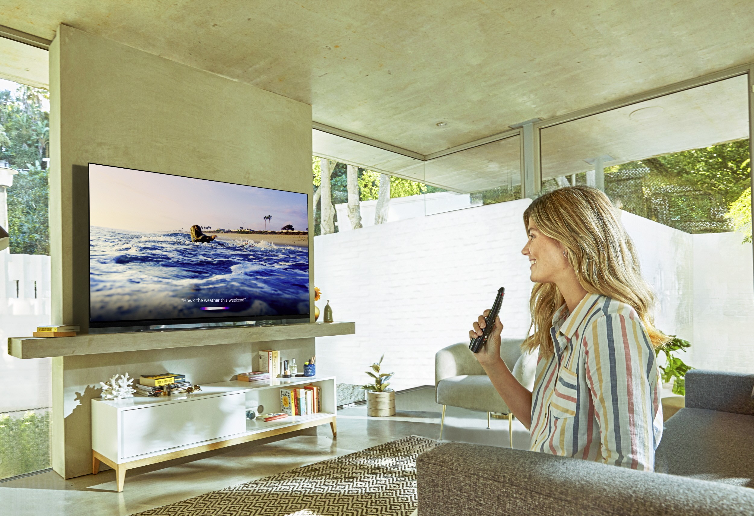 A lady watching the LG OLED TV with LG ThinQ AI at her home