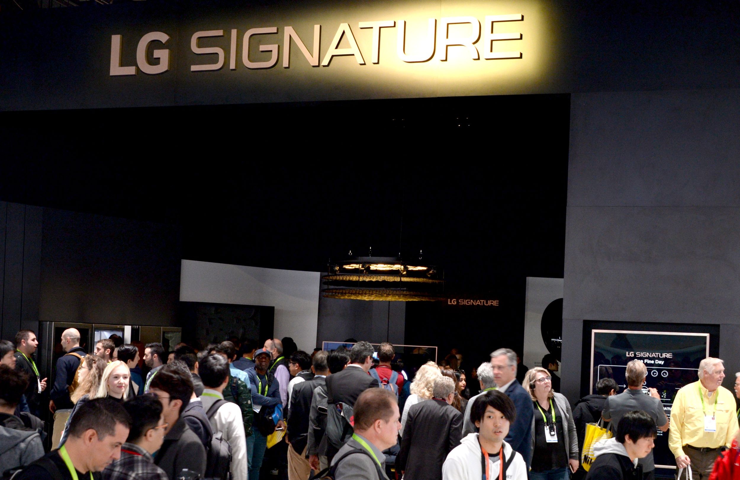 Conference attendees walk around the LG SIGNATURE display zone at CES 2019.