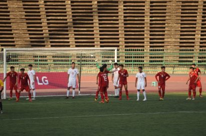 Players wait for a corner-kick inside the penalty box and there is LG’s pitch-side advertisement board behind the goal.