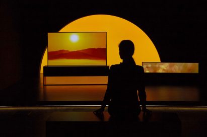LG SIGNATURE OLED TV R model 65R9 displayed in the dark for the Redefining Space installation, with a model standing in front at Milan Design Week.