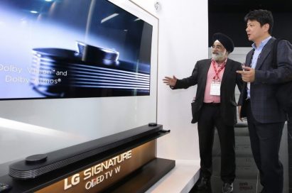 Two attendees discuss the Dolby Vision and Dolby Atmos technologies implemented in LG SIGNATURE OLED TV W.