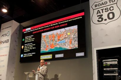 LG’s large display hangs against the wall over the podium for a presentation session during the Road to ATSC 3.0 exhibit event.