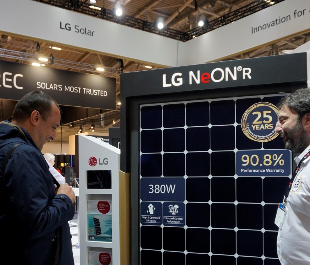 A male attendant explains the main features of LG NeON R high performance solar panel to a visitor.