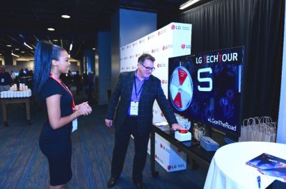 A woman takes an attendee through LG’s promotional spin the wheel game.