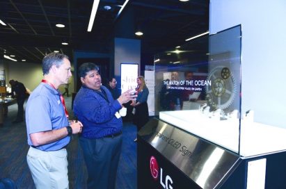 Two attendees discuss about the new Transparent LG OLED display.