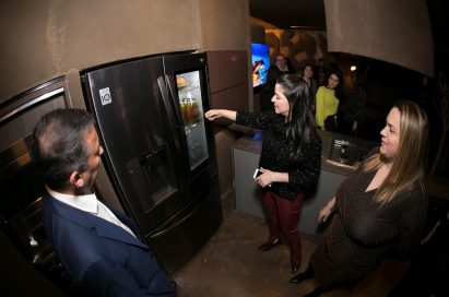 Visitors discuss the LG SIGNATURE InstaView Door-in-Door Refrigerator at LG’s Planet Home.