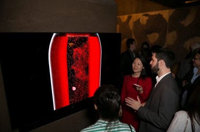 Visitors look at and discuss LG’s 77-inch OLED TV inside of LG’s Planet Home.