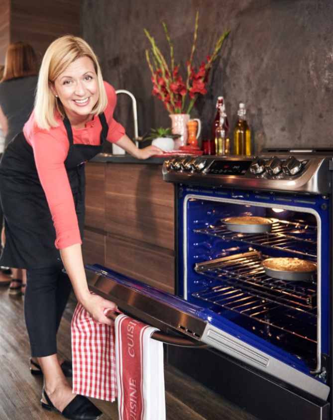 A lady in red shirts opens the door of the LG ProBake Convection® with the casserole inside the oven.