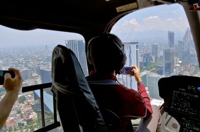 A pilot and a passenger take photos in the helicopter by using LG Q60.