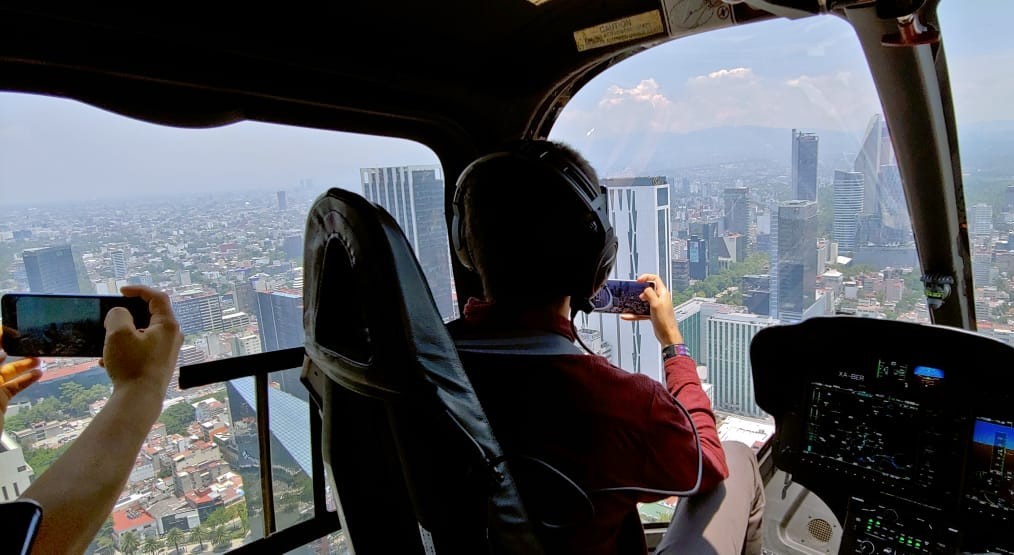 A pilot and a passenger take photos in the helicopter by using LG Q60.