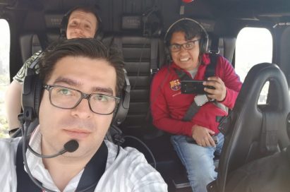 A selfie of three people in the helicopter taken by the pilot