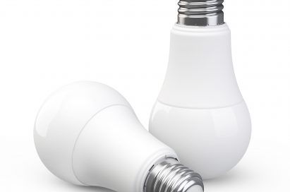 One LED light bulb laid down in front of an identical LED light bulb standing upright