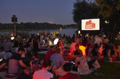 Audiences sit on the picnic mats at the nightfall and chatter before the movie starts