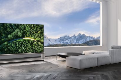 The LG SIGNATURE OLED 8K TV model 88Z9 showing a road in the woods is placed in a modern, spacious room with a spectacular view