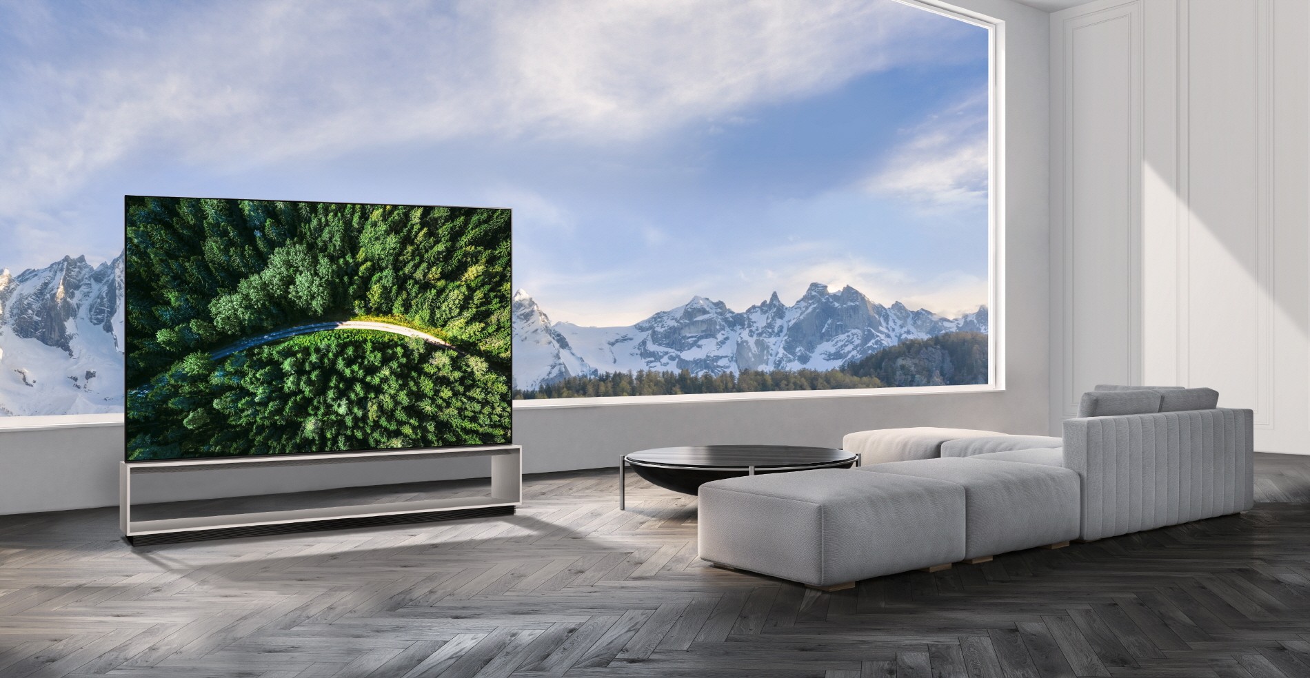 The LG SIGNATURE OLED 8K TV model 88Z9 showing a road in the woods is placed in a modern, spacious room with a spectacular view