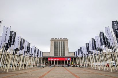 Front view of Messegelände Berlin ExpoCenter City with promotional flags of the LG SIGNATURE brand and its brand theme “The Art of Essence” flying in front